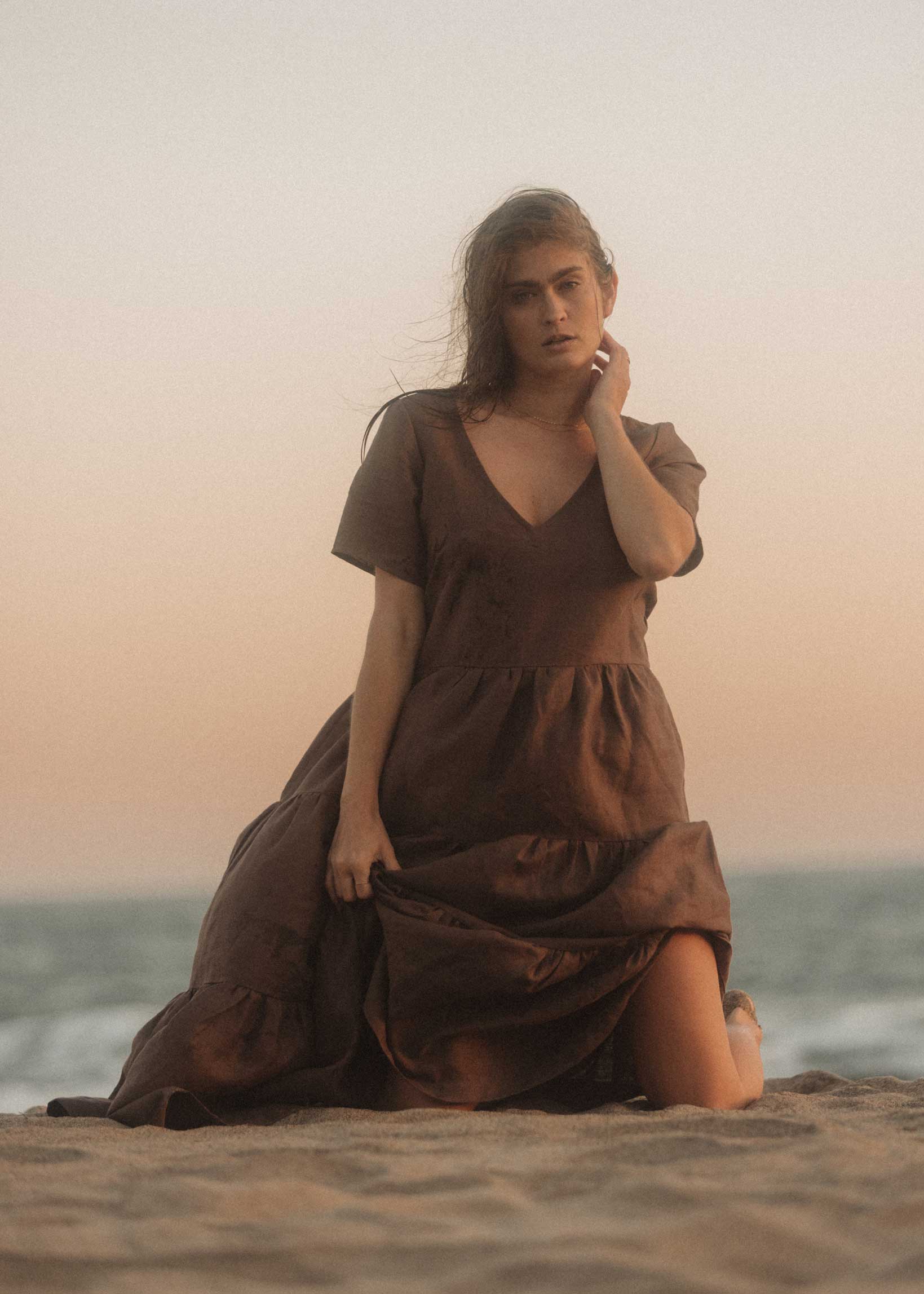 The Elwood Maxi dress in Mocha on the beach in Australia during golden hour. Our model shows off the beautiful tiers and volume of the dress with a big smile on her face.