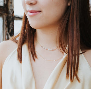 model wearing the goddess necklace and the pearl strand