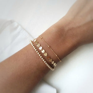 gold filled coin bracelet layered with satellite chain bracelet and gold beaded bracelet