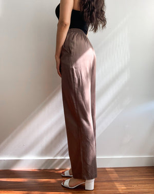 Light brown loose trousers made from organic cotton and tencel,with back elastic waistband worn with a black tank top.