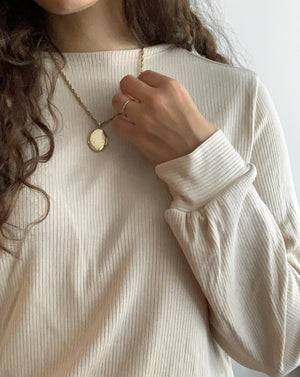 Sustainable beige ribbed tencel reversible shirt with gold necklace.