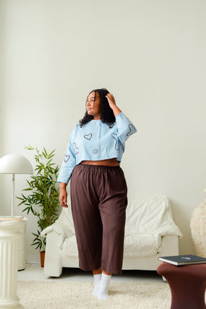 Plus size model wearing wide leg dark brown pants and a blue printed top