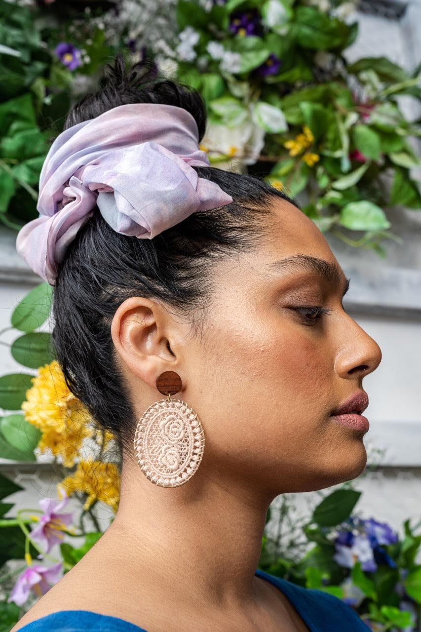 Model Malathecitymonk Mala, wears the sustainable GOTS cotton voile long scarf in the this is willow custom tie dye pink print. the scarf is tied in a knot around the bun in her hair. Mala faces right, in a profile of the side of her face. Photo by Picnchu89.