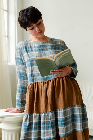  non binary model reading a book wearing a color blocked long sleeve loose fitting dress